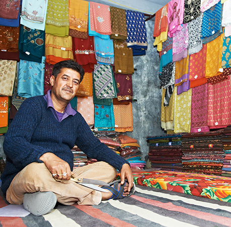 small-shop-owner-indian-man-selling-shawls-clothing and-souvenirs-at-his-store